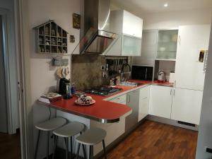 a kitchen with a red counter top and white cabinets at Appartamento La collina del sole in Lerici