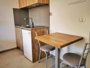 eine kleine Küche mit einem Holztisch und Stühlen in der Unterkunft Ustaria in Peri