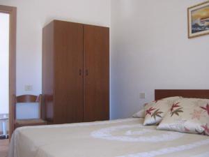1 dormitorio con 1 cama y armario de madera en Villa Medina, en Vieste
