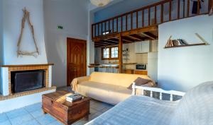 een woonkamer met een bed en een open haard bij Casa Sofianna 2-bedroom home next to sandy beach in Monemvasia