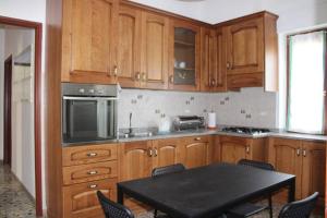 eine Küche mit Holzschränken und einem Tisch mit Stühlen in der Unterkunft Appartamento La Cicala in Barga