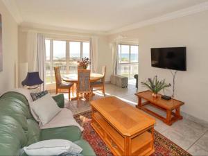 a living room with a green couch and a table at Summerseas Units in Summerstrand
