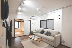 uma sala de estar com um sofá e uma mesa em Gallery House em Tóquio