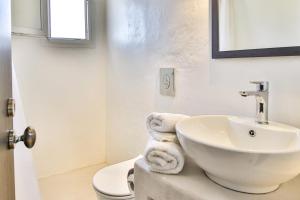 a white bathroom with a sink and a toilet at Lilly's Sunset Suite in Mikonos
