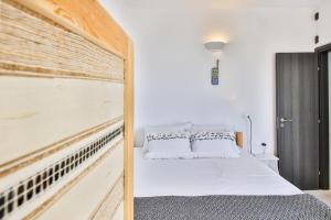 a bedroom with a bed with a wooden headboard at Lilly's Sunset Suite in Mikonos