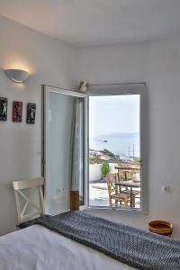 a bedroom with a bed and a large sliding glass door at Lilly's Sunset Suite in Mikonos