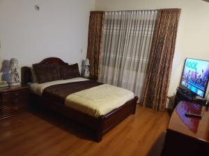 una camera con letto e TV a schermo piatto di Hotel El Cid Plaza Premium a Tunja