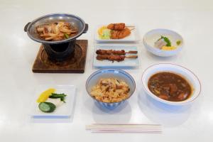 a table with plates of food and bowls of food at Tabist Daibou Ichihara Mens Only in Ichihara