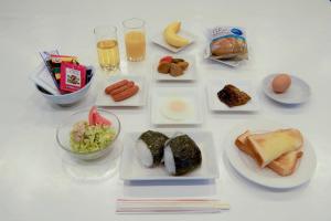 a white table topped with plates of food and drinks at Tabist Daibou Ichihara Mens Only in Ichihara