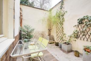 een klein balkon met een glazen tafel en stoelen bij Le Bailly in Nancy