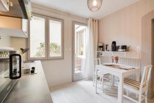 una cucina con tavolo e tavolo e sedie bianchi di Le Bailly a Nancy