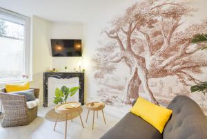 a living room with a tree mural on the wall at Le Bailly in Nancy