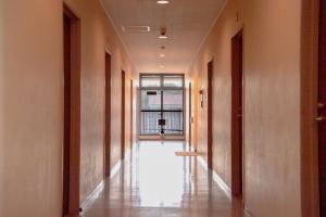 an empty corridor in a building with a window at Tabist Daibou Ichihara Mens Only in Ichihara