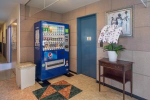 a blue vending machine in a room with a table at Tabist Daibou Ichihara Mens Only in Ichihara