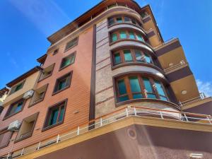 a tall brown building with a round at Beach Apartments Pomorie in Pomorie