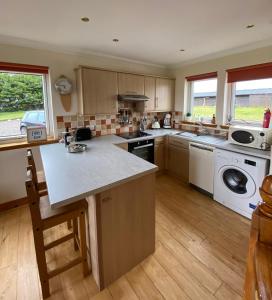 a large kitchen with a sink and a dishwasher at Cleadale flat in Breakish