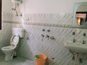 a bathroom with a toilet and a sink at Debbhumi Regency in Sāngla
