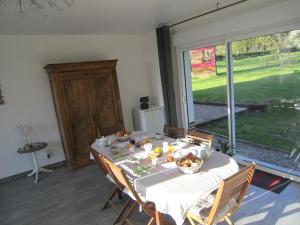 comedor con mesa y ventana grande en Les Chambres de Pascaline, en Arrest