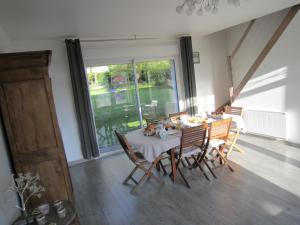 a dining room with a table and chairs and a large window at Les Chambres de Pascaline in Arrest
