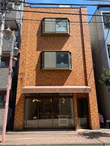 um edifício de tijolos com uma janela em cima em Gallery House em Tóquio