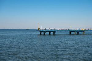 a pier in the middle of the water with people on it at Tabist Daibou Ichihara Mens Only in Ichihara