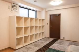 a room with empty shelves and a door at Tabist Daibou Ichihara Mens Only in Ichihara