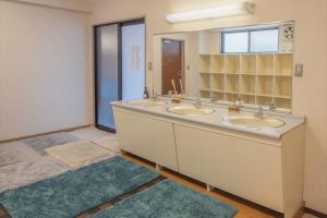 a bathroom with three sinks and a large mirror at Tabist Daibou Ichihara Mens Only in Ichihara