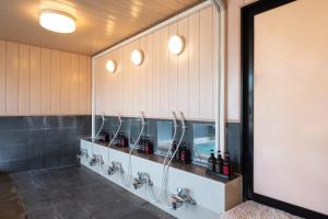 a bathroom with a row of sinks and mirrors at Tabist Daibou Ichihara Mens Only in Ichihara