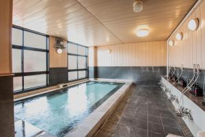 a large indoor swimming pool in a building at Tabist Daibou Ichihara Mens Only in Ichihara