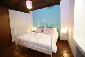 1 dormitorio con cama blanca y almohadas rosas en relax nel borgo L'ARCHETTO, en Formello