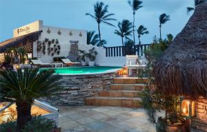 杰里科科拉Mona Lisa Pousada的棕榈树后院的游泳池