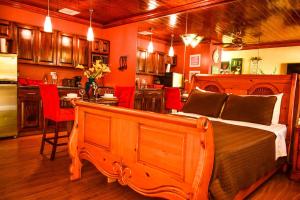 a bedroom with a bed and a kitchen with a table at Brownstone Guesthouses Seabeach in Nassau