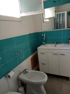 uma casa de banho com um WC branco e um lavatório. em Appartamento vacanze Piazza del Popolo em Marsala