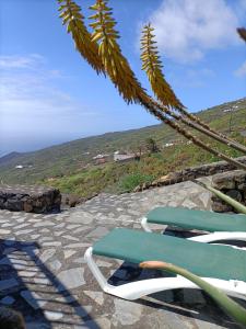 un par de sillas sentadas en la parte superior de un patio de piedra en El Somadero B en Fuencaliente de la Palma