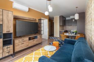 sala de estar con sofá azul y TV de pantalla plana en Vision Apartments Budapest Exclusive, en Budapest