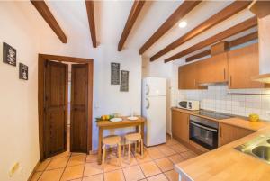 a kitchen with wooden cabinets and a table and chairs at Ca Na Magda in Port de Soller