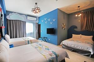 um quarto com duas camas e uma parede azul em Fun Trip - Little Castle & Oscar B&B em Taitung City