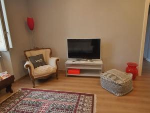 a living room with a tv and a chair and a table at Foscolo 27 a 100 m dal mare in Viareggio