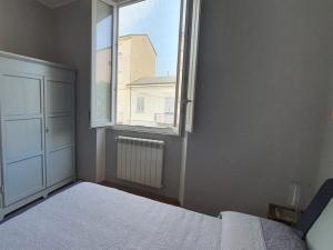 an empty bedroom with a bed and a window at Foscolo 27 a 100 m dal mare in Viareggio