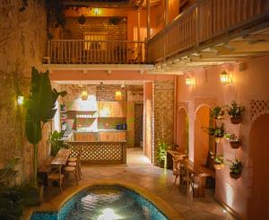 - une piscine au milieu d'une terrasse avec une table et des chaises dans l'établissement Casa Zahri Boutique Hostel, à Carthagène des Indes