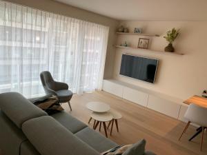 a living room with a couch and a tv at Pluk de dag in Oostduinkerke