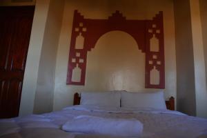 ein Schlafzimmer mit einem Bett mit einem Bogen darüber in der Unterkunft Hotel Trans Sahara Merzouga in Merzouga