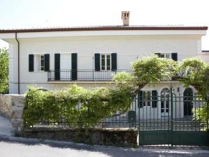 a white house with a green fence at Villa Cascate in Bagnone