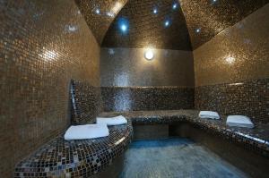 un bagno con due lavandini in un muro di mattoni di Taurus Hotel & SPA a Lviv