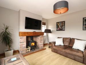 a living room with a couch and a fireplace at Hall Farm Cottage in Louth