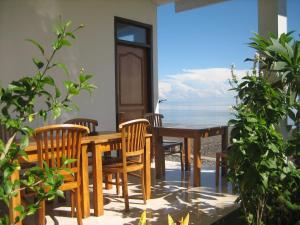 a table and chairs on a patio with the ocean at Lucky Paradise Bungalows on The Beach in Amed