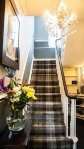 a staircase with a vase of flowers on a table at Cumbrian Lodge in Seascale +18 photos