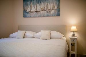 a bed with white pillows and a painting on the wall at Villa Luka Lopar in Lopar +48 photos
