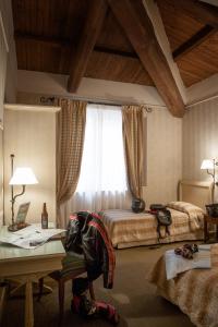 a bedroom with two beds and a desk and a window at Hotel Selva Candida in Selva Candida 