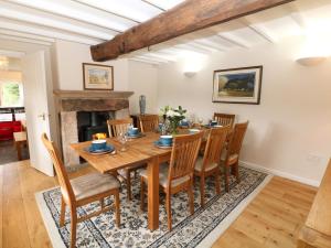 a dining room with a table and chairs and a fireplace at Broadwood Farm in Hathersage